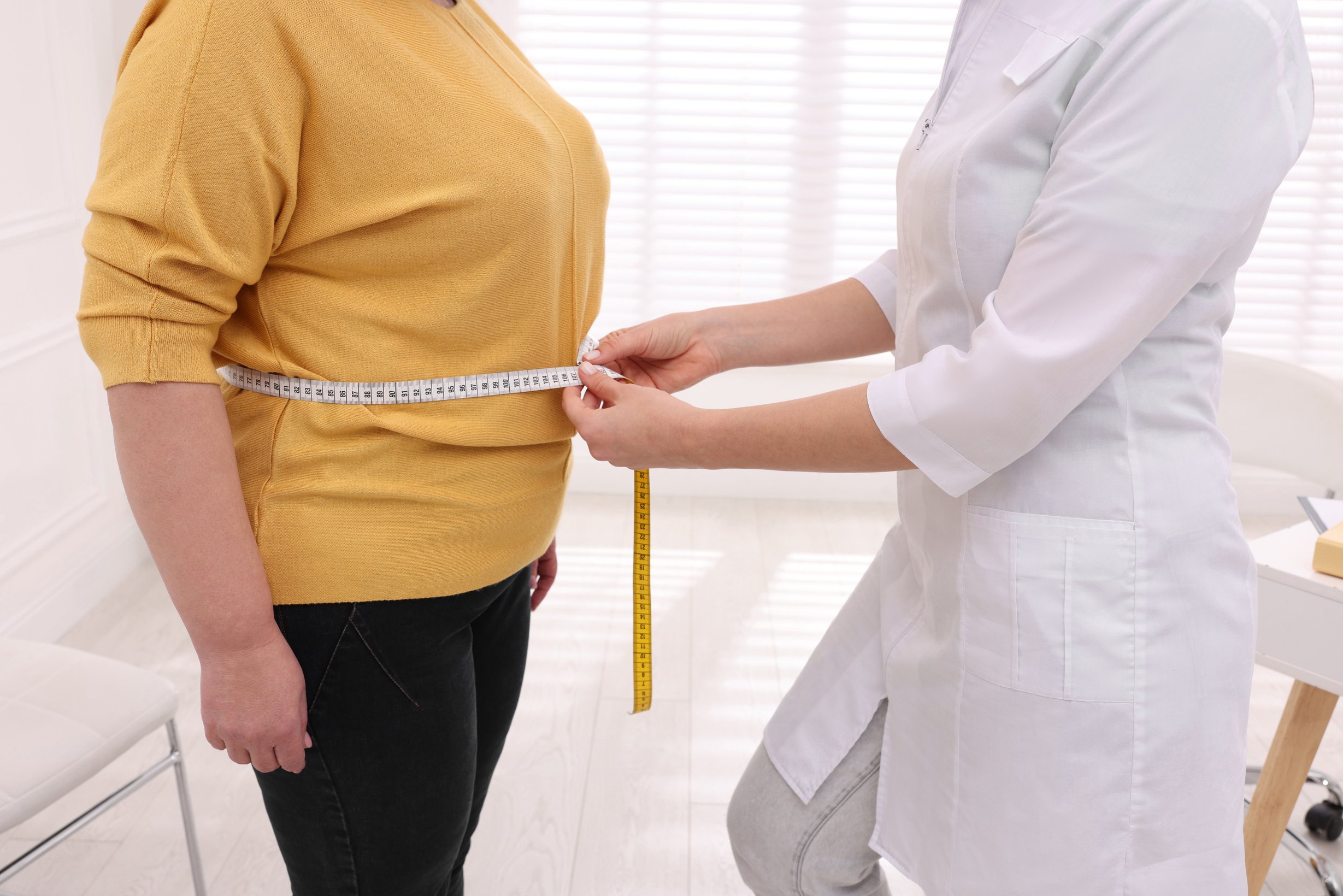 Nutritionist Measuring Woman's Waistline